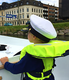 liten pojke med flytväst och kaptenshatt