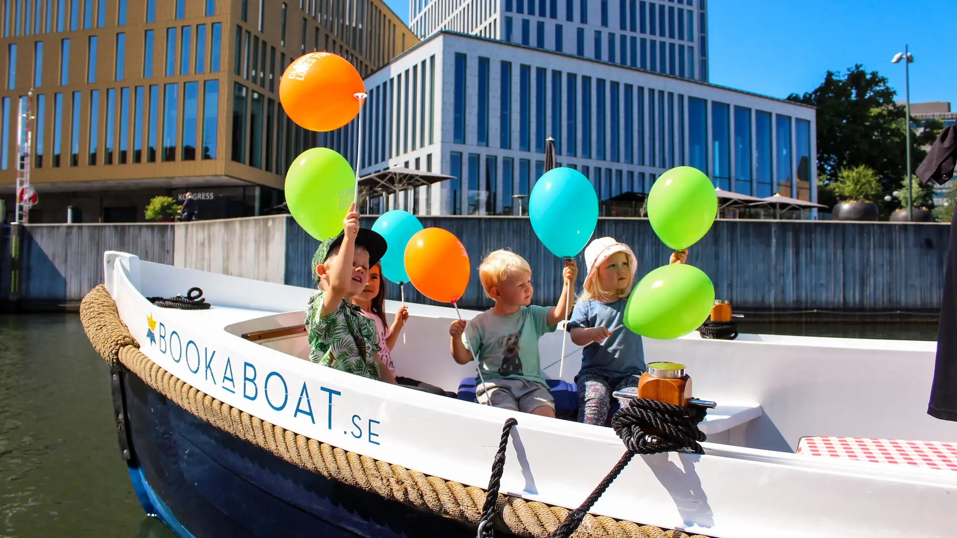 Barn i en båt med ballonger